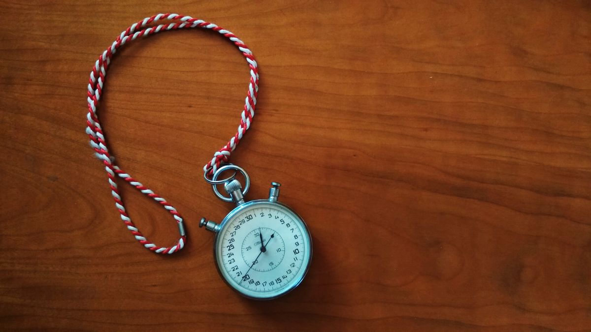 A mechanical stopwatch on a wooden panel